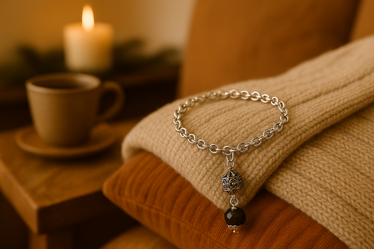 Il bracciale "AURORA" è un monile artigianale tipico della Sardegna, impreziosito dalla presenza di una o più perle nere lucide chiamate “su coccu”. Queste perle, spesso in onice, hanno una forma rotonda e liscia, e sono inserite nel bracciale con piccoli ornamenti filigranati, in questo caso piccolo bottone sardo.